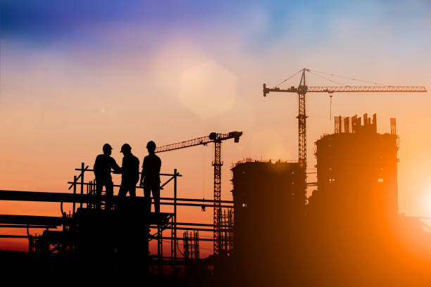 Silhouette of engineer and construction team working at site over blurred background for industry background with Light fair.Create from multiple reference images together